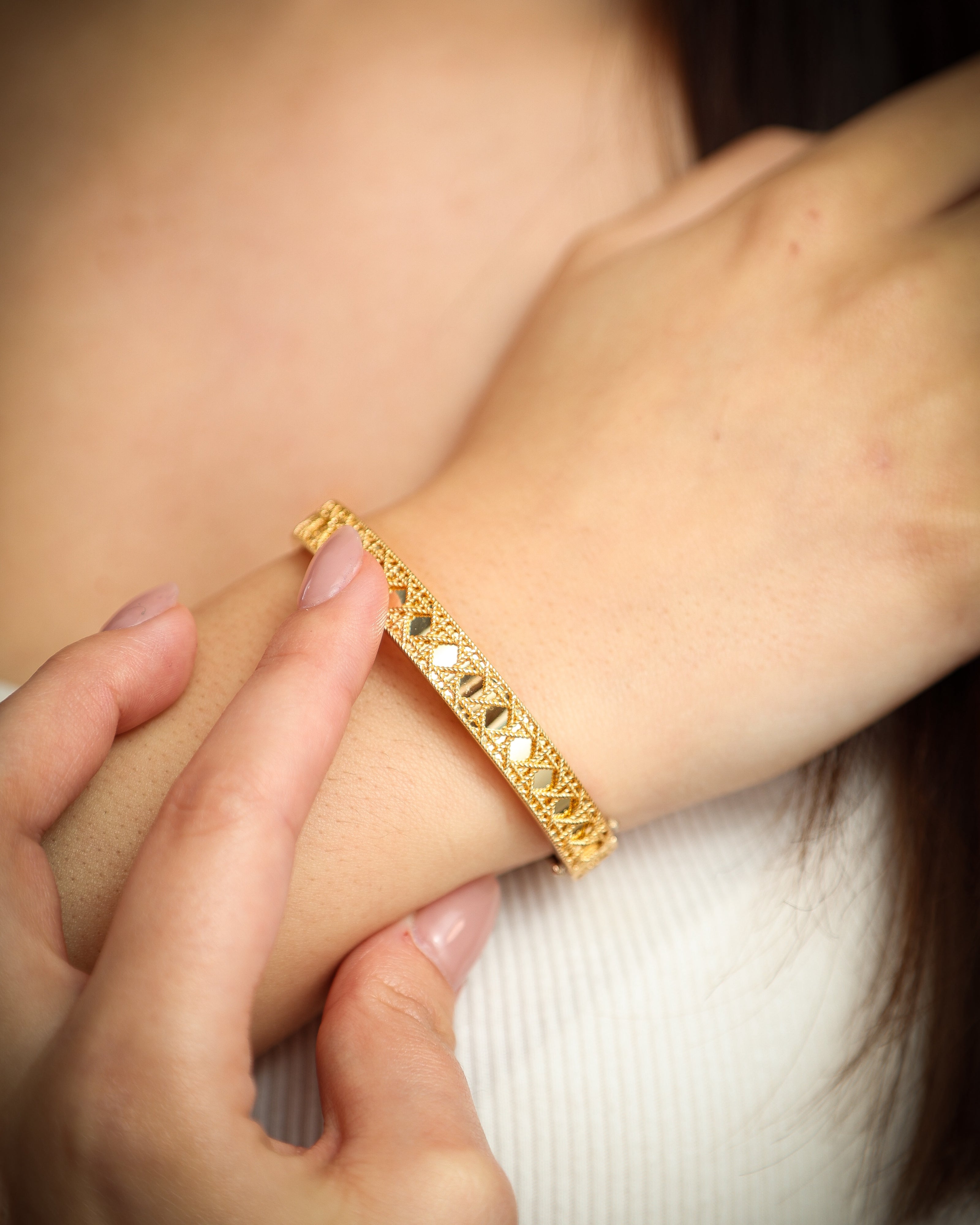 Aurora 14K yellow gold bracelet worn on a woman’s wrist